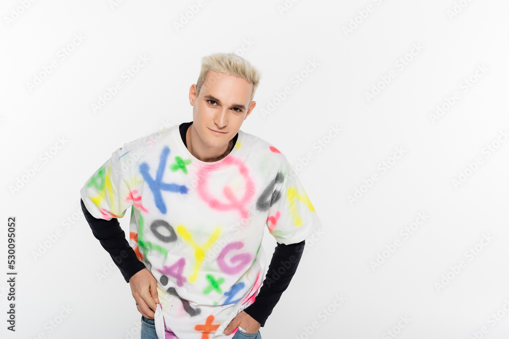 blonde gay man in stylish t-shirt looking at camera isolated on grey. blonde gay man in stylish t-shirt looking at camera isolated on grey.