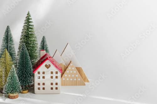 Miniature houses and fir trees on white background. Winter cute landscape. Cozy small world. Christmas decorations, holiday concept. .