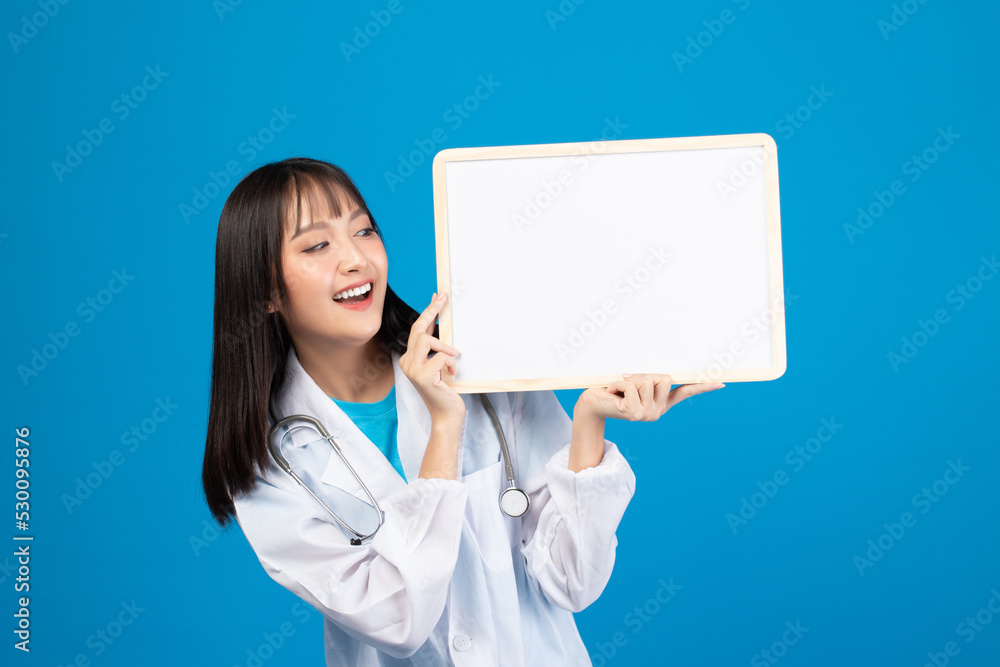 Smiling doctor holding blank banner or card with stethoscope on blue background Smiling doctor holding blank banner or card with stethoscope on blue background