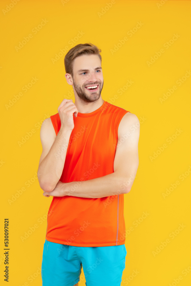 Athletic man looking aside. Happy sportsman isolated on yellow. Sporting man studio. Fitness Athletic man looking aside. Happy sportsman isolated on yellow. Sporting man studio. Fitness