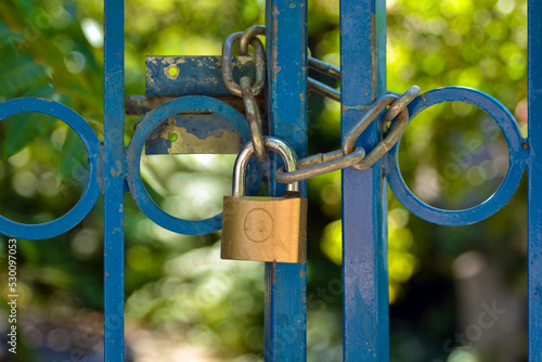 Iron lock locked garden green with blue  gate