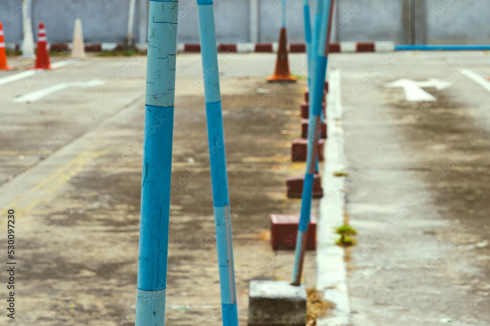 Fototapeta premium Driving test and training area with simulate test for driving license. Driving school practice traffic area with pole signs and orange cones and road signs for safety on concrete road. Selective focus