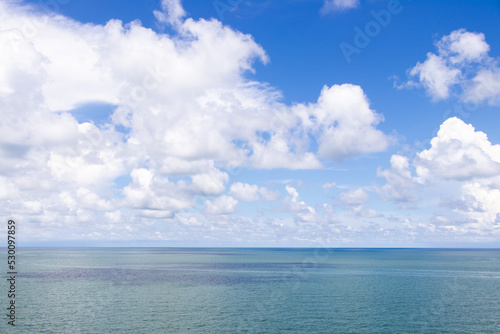 Beautiful calm turquoise color sea and blue sky with white color cloud background