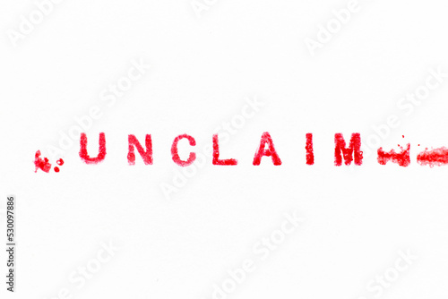 Red color ink rubber stamp in word unclaim on white paper background