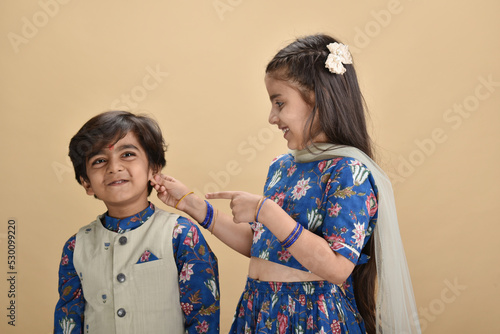 Indian asian cute little kids or siblings celebrating festival 