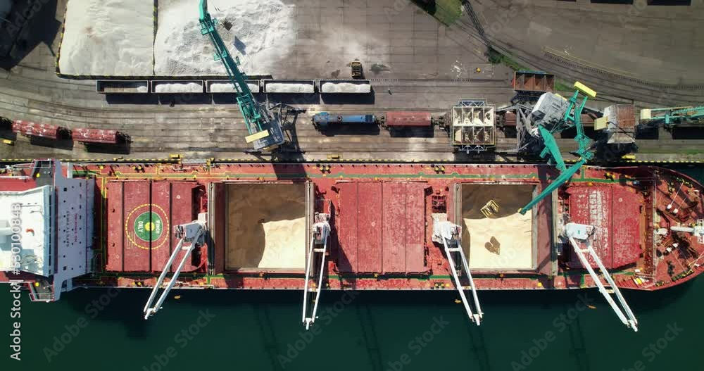 Cargo ship loading and unloading operations on board, aerial view. Cargo delivery by sea. The
