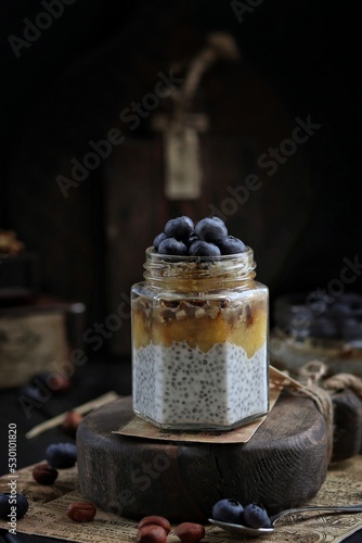 Fototapeta Naklejka Na Ścianę i Meble -  Chia pudding with blueberries in a jar on a wooden board