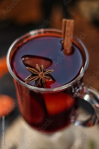 Non-alcoholic mulled wine with orange, cinnamon and honey on a wooden stand. Autumn mood. photo