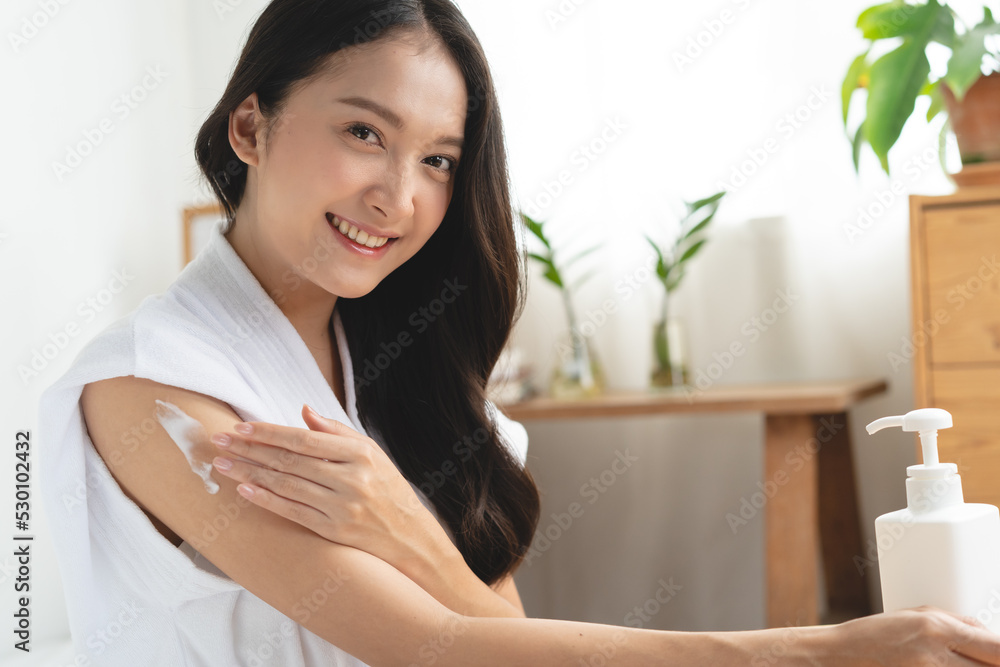 Young woman applying moisturizer cream to her arm in the morning routine. Young woman applying moisturizer cream to her arm in the morning routine.