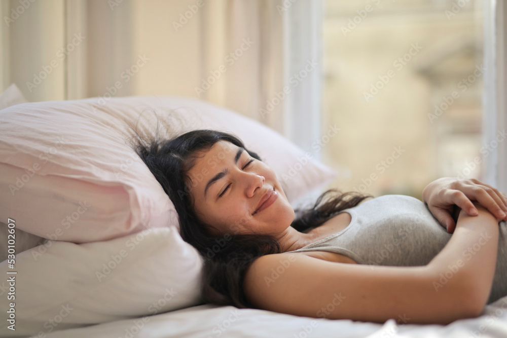 young woman sleeps in bed
