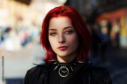 close up young adult woman outside blue eyes with punk spike choker photo