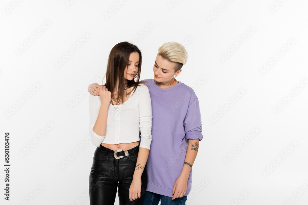 young and stylish lesbian partners holding hands isolated on grey. young and stylish lesbian partners holding hands isolated on grey.
