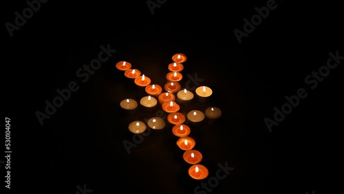 Japanese Yen Symbol Made of Burning Votive Candles Black Back Ground photo