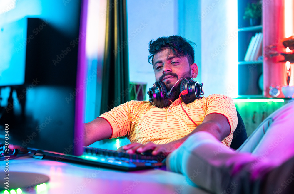 young man got board by playing videos games on computer at home during holidays - concept of exhausted, lazy and entertainment young man got board by playing videos games on computer at home during holidays - concept of exhausted, lazy and entertainment