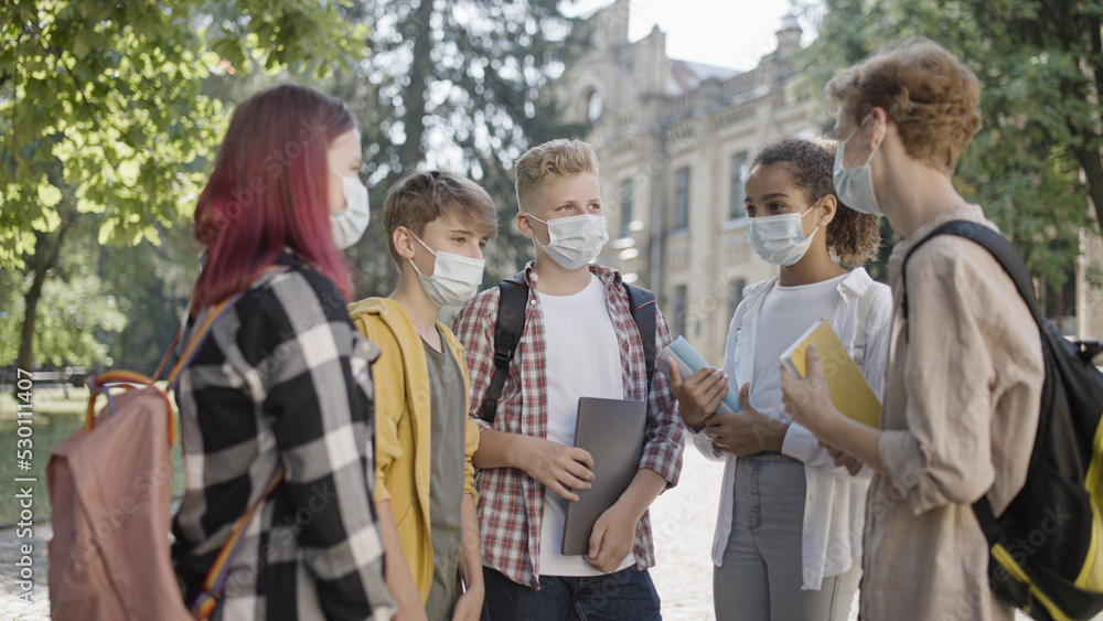 Group of school students wearing protective face masks on campus, pandemic safety Group of school students wearing protective face masks on campus, pandemic safety