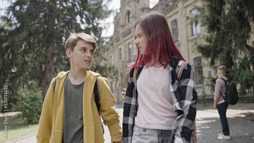 School couple holding hands, walking home together after classes, first date School couple holding hands, walking home together after classes, first date