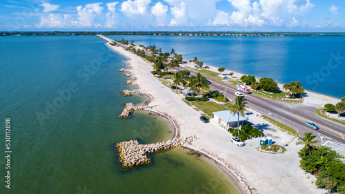 Aerial Drone Close Up of the Causeway Bridge in Sanibel, Florida with the Bay and a Preserve in the Foreground and the Gulf of Mexico in the Background Featuring a Blue Sky and Blue Water photo