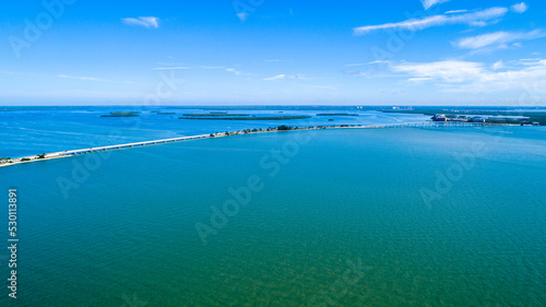 Aerial View of the Causeway Before Hurricane Ian in Sanibel, Florida with the Bay and a Preserve in the Foreground and the Gulf of Mexico in the Background Featuring a Blue Sky and Blue Water