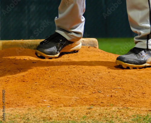 Youth Pitcher Set before pitch during an evening baseball game.