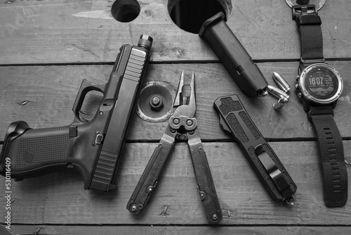 Men's edc carry kit, pistol, smart watch, multitool and folding knife.
