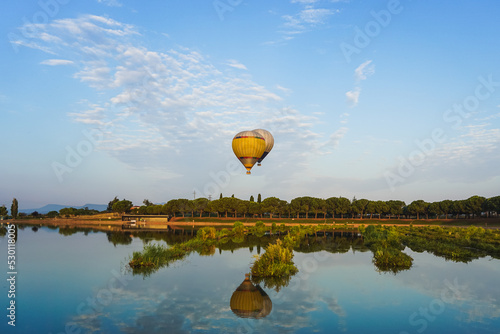 hot air balloons flying over the lake