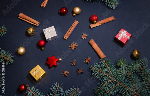 Christmas background made of fir branches, balls, spices and gift boxes.