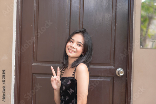 Tableau sur toile A pretty young lady holds up a peace sign as she smiles for the camera