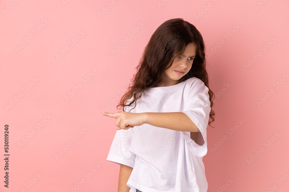 Get out. Portrait of little girl wearing white T-shirt showing exit, demanding to leave her alone, turning away with resentful irritated expression. Indoor studio shot isolated on pink background. Get out. Portrait of little girl wearing white T-shirt showing exit, demanding to leave her alone, turning away with resentful irritated expression. Indoor studio shot isolated on pink background.