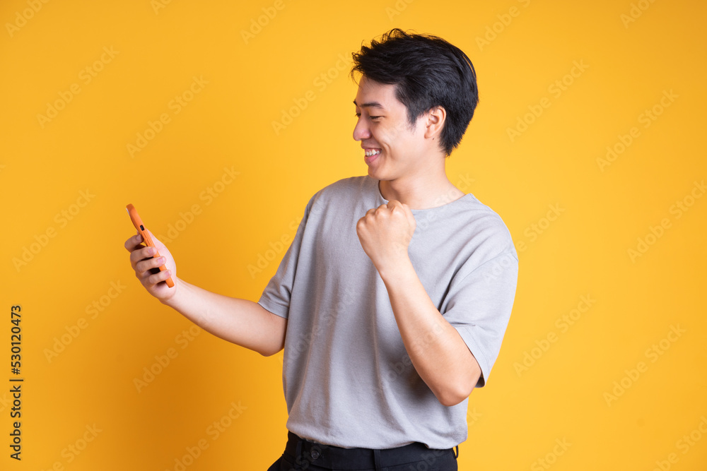 Asian young man posing on a yellow background Asian young man posing on a yellow background