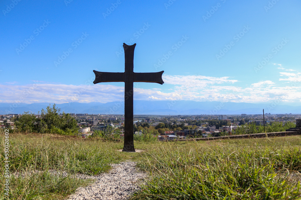 Cross on the hill with Georgian city landscape on background Cross on the hill with Georgian city landscape on background