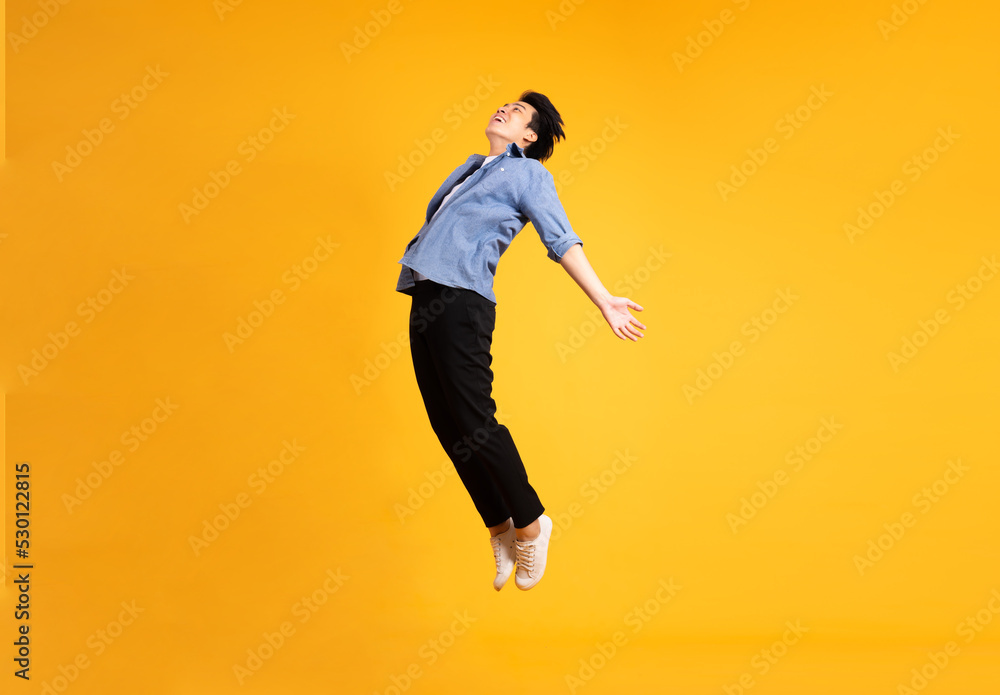 full body image of asian man posing on yellow background full body image of asian man posing on yellow background