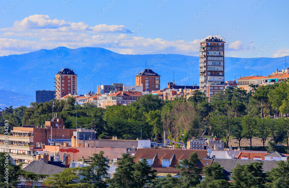 Madrid cityscape with the dome of Teatro la Estacion and residential buildings overlooking Sierra de Guadarrama mountain, Madrid, Spain