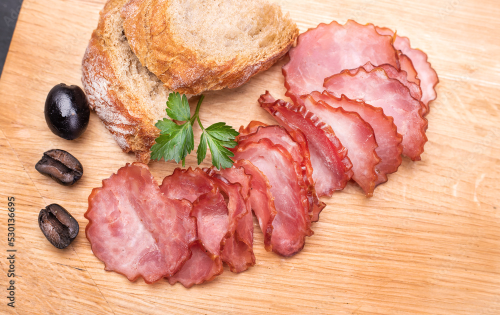 Rustic composition with a smoked, dry Krakowska sausage. Traditional Polish meat cold cuts.