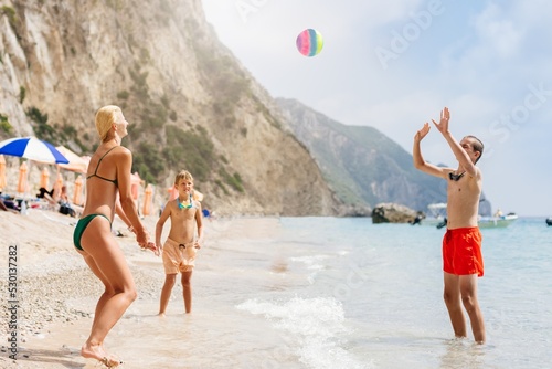 Obraz na płótnie Happy family on the beach in Corfu, Greece. Mother plays ball with her two sons. Happy summer vacations w salonie