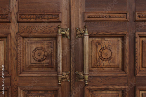 Antique massive wooden doors with large handles close-up. Ancient architecture