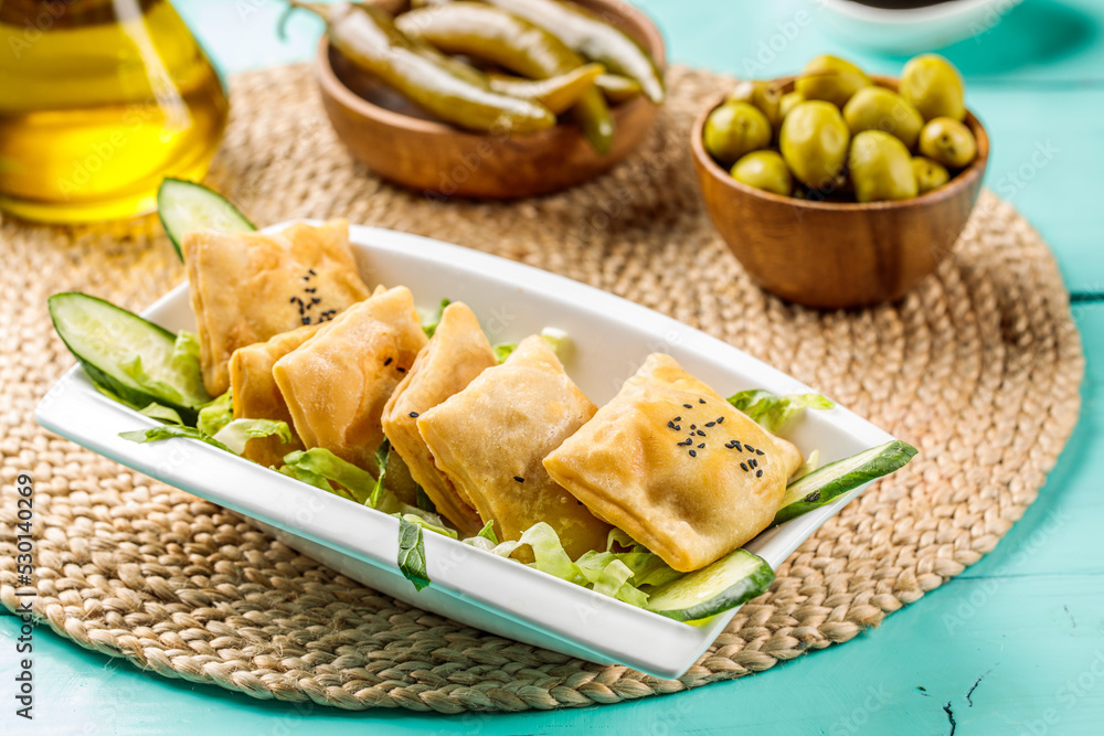 Fried Sambosek Cheese with olive served in dish isolated on wooden table side view of middle eastern food Fried Sambosek Cheese with olive served in dish isolated on wooden table side view of middle eastern food