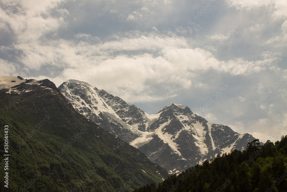 Dramatic mountain slopes with glaciers and sharp peaks in Kabardino-Balkaria of Russia and cloudy dramatic sky