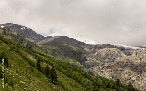 Dramatic mountain slopes with glaciers and sharp peaks in Kabardino-Balkaria of Russia and cloudy dramatic sky