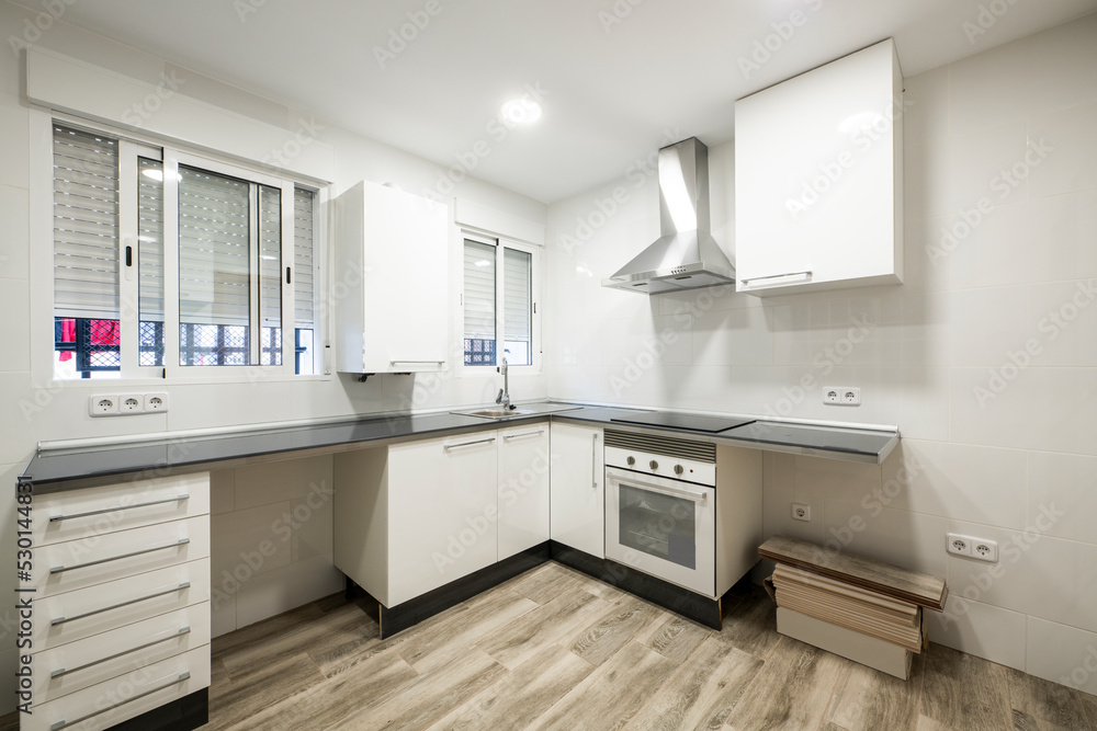 corner kitchen with white cabinets and missing some appliances with wood-look stoneware floors corner kitchen with white cabinets and missing some appliances with wood-look stoneware floors