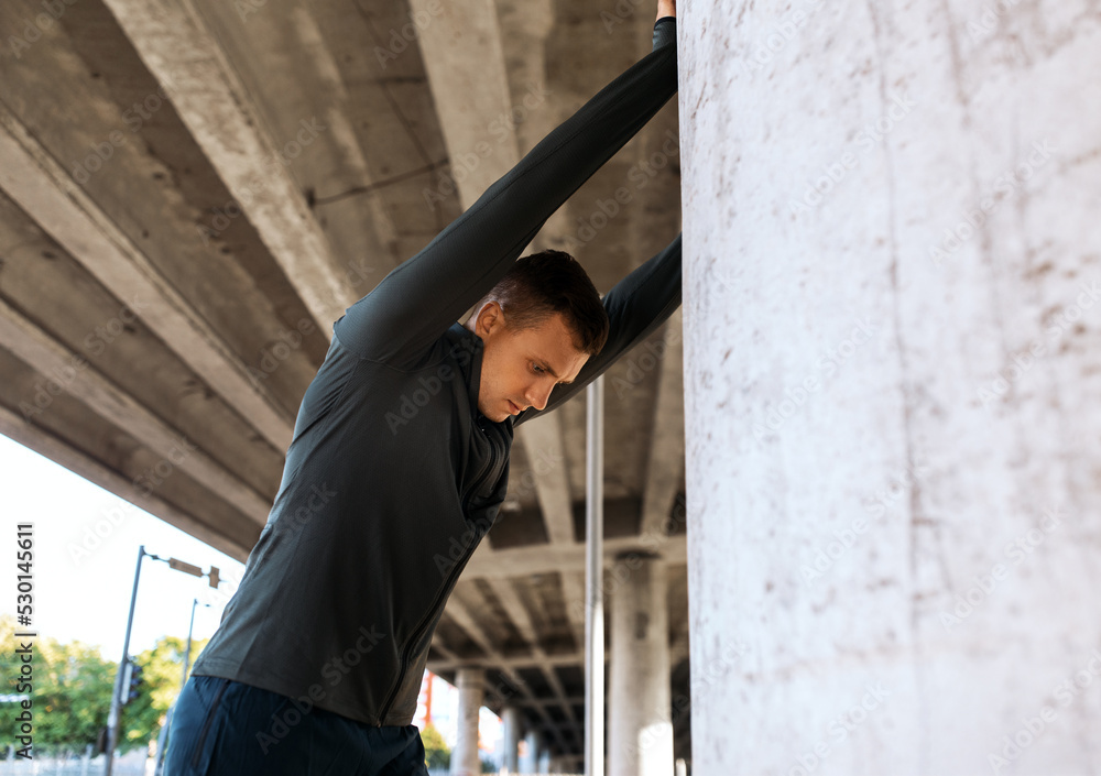 fitness, sport and healthy lifestyle concept - man stretching back under bridge