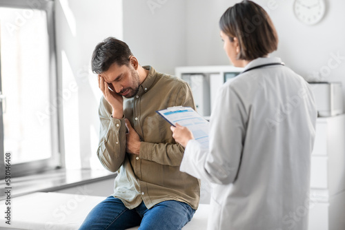 medicine, healthcare and people concept - female doctor with clipboard and sad male patient having health problem at hospital © Syda Productions
