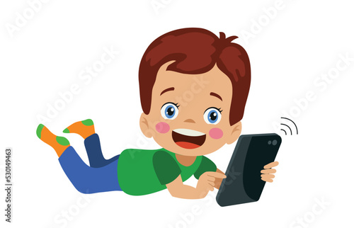 happy cute boy playing with his phone lying down