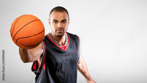 Young male basketball player holding ball, sports lifestyle.