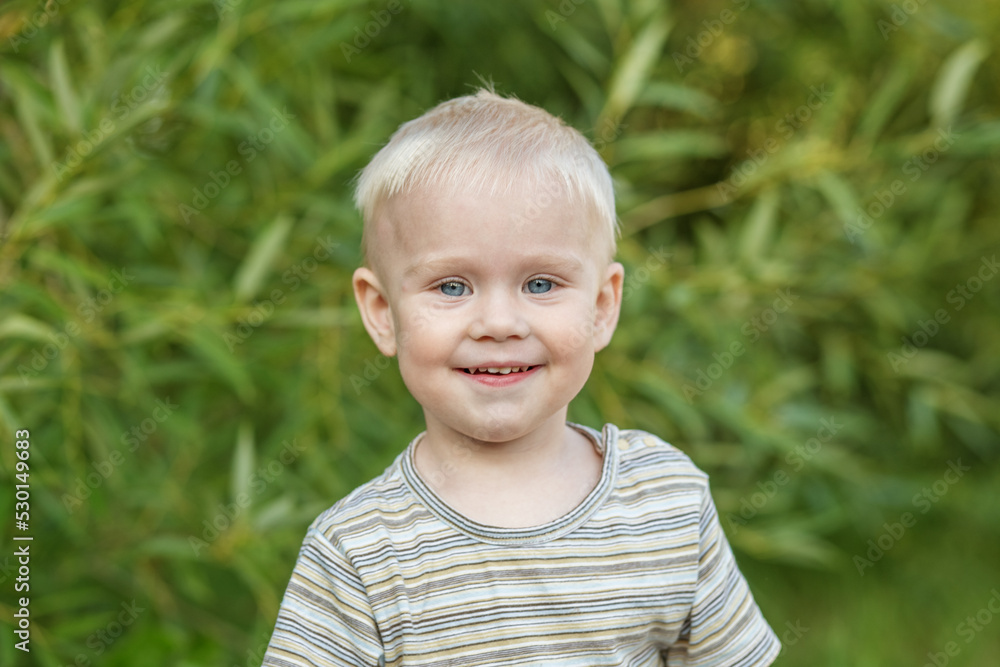 Portrait of smiling toddler boy in striped t-shirt. Close-up. Concept of kindergarten, education Portrait of smiling toddler boy in striped t-shirt. Close-up. Concept of kindergarten, education