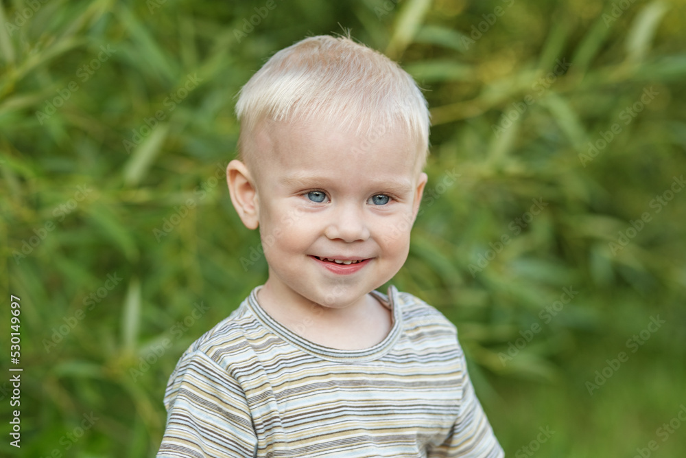 Portrait of smiling toddler boy in striped t-shirt. Close-up. Concept of kindergarten, education Portrait of smiling toddler boy in striped t-shirt. Close-up. Concept of kindergarten, education