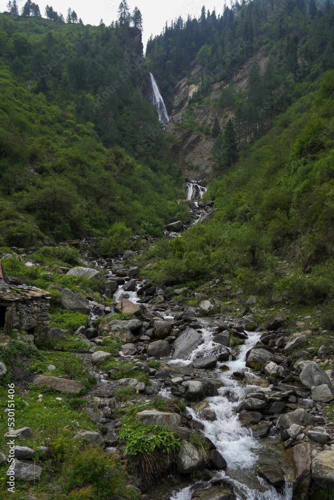 Beautiful and spectacular natural waterfall falling through rocky mountains enroute har ki dun valley. A perfect morning landscape of lush green and rocky mountains and powerful waterfall. Beautiful and spectacular natural waterfall falling through rocky mountains enroute har ki dun valley. A perfect morning landscape of lush green and rocky mountains and powerful waterfall.