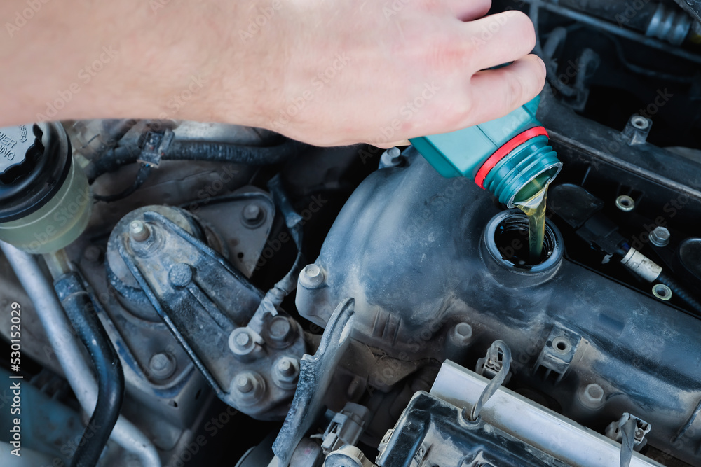 Fototapeta premium pouring engine oil into the engine