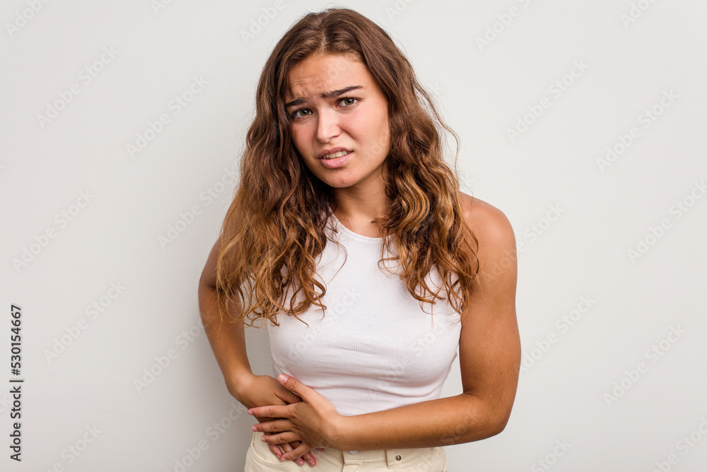 Young caucasian woman isolated on blue background having a liver pain, stomach ache. Young caucasian woman isolated on blue background having a liver pain, stomach ache.