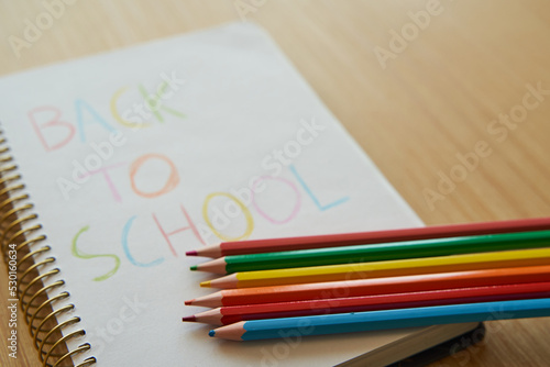 Kids notebook with back to school message with color pencils