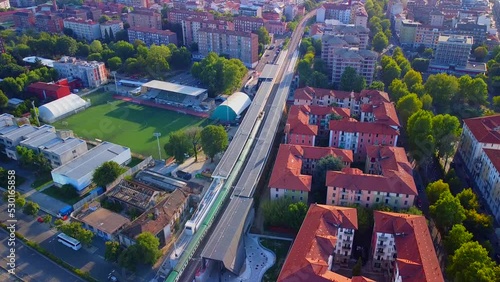 Aerial view of the station. Trains arrive at the station. An old wide arched structure of metal and glass above the station pillars. Tourism. Skyline with tall buildings. Italy, Milan, photo